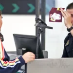 US border officer checking a traveller’s passport during new proposed ESTA social media screening rules.