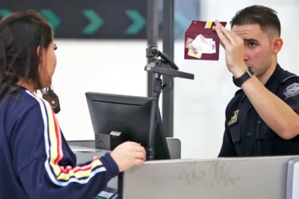 US border officer checking a traveller’s passport during new proposed ESTA social media screening rules.