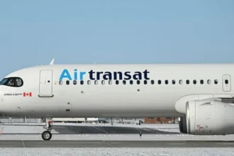 Air Transat aircraft taxiing on a snowy runway under a clear sky