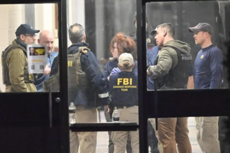 FBI agents and local police gather inside a Brown University building as investigators continue searching for the gunman after a person of interest was released.