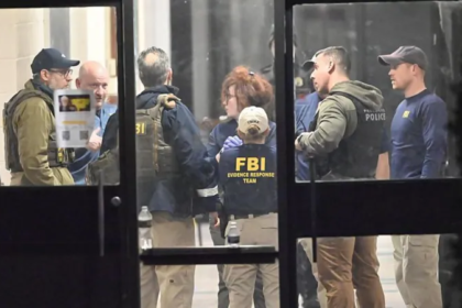 FBI agents and local police gather inside a Brown University building as investigators continue searching for the gunman after a person of interest was released.
