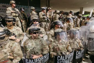California National Guard troops in full riot gear standing in formation during a public protest response