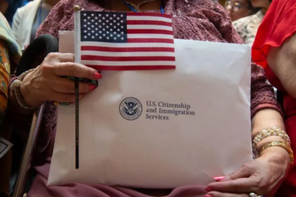 Immigrant holds US flag and USCIS documents as citizenship ceremonies are cancelled under new immigration restrictions