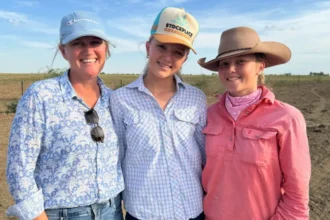 Teenagers using smartphones outdoors in rural Australia, highlighting digital connectivity and social media access challenges.