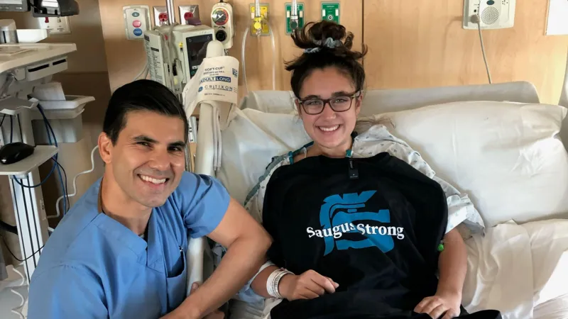 Brown University student Mia Tretta smiles in a hospital bed while recovering after surviving the 2019 Saugus High School mass shooting