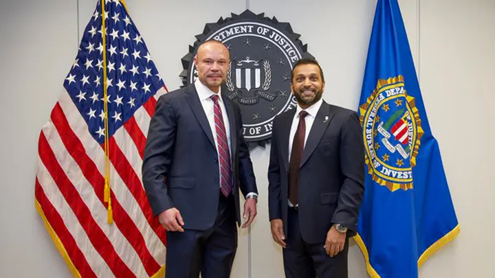 Dan Bongino smiling while speaking at FBI event, thanking Kash Patel for his praise