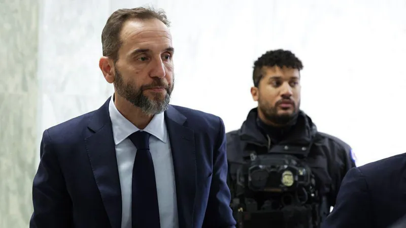 Former special counsel arrives for a closed door congressional hearing, accompanied by a security officer inside a government building