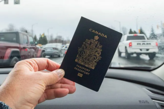 A hand holding a Canadian passport inside a car, symbolizing new citizenship rights under Canada’s Lost Canadians citizenship law.