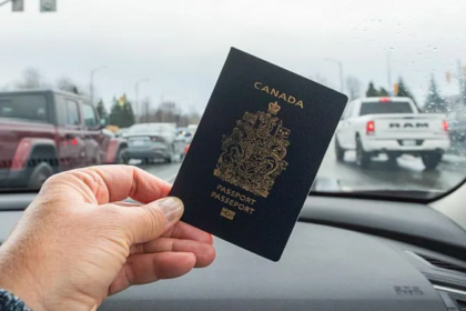 A hand holding a Canadian passport inside a car, symbolizing new citizenship rights under Canada’s Lost Canadians citizenship law.
