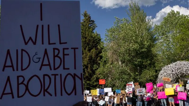 Wyoming Supreme Court building with people reacting after the ruling that keeps abortion legal in the state