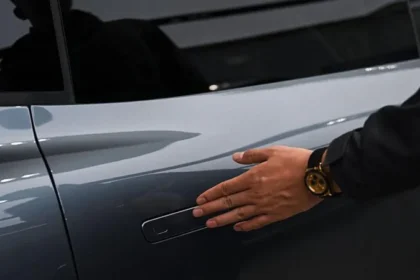 China has officially banned hidden car door handles in electric vehicles due to growing safety concerns. The country is the first in the world to take this step. The move follows several deadly accidents where passengers could not open car doors during emergencies. The new rule mainly affects electric vehicles, hybrids, and fuel cell cars. These models fall under China’s new energy vehicle category. Safety incidents push regulators to act Chinese regulators acted after multiple serious crashes raised alarm. Two fatal accidents involving Xiaomi electric cars sparked major concern. Investigators believe power failures stopped the electronic door systems from working. As a result, passengers could not exit the vehicles in time. Hidden door handles became popular after Tesla introduced them. Many manufacturers later copied the design. While the handles improve appearance and airflow, they depend heavily on electricity. This creates a risk during crashes or power loss. New rules require mechanical door releases China’s Ministry of Industry and Information Technology now requires all passenger doors to include mechanical handles. This applies to both the inside and outside of the vehicle, except for the boot. Each outside door must include a recessed space large enough for easy access. The space must measure at least six centimeters by two centimeters by two point five centimeters. Inside the car, clear signs must show how to open the door manually. These signs must meet minimum size requirements so passengers can spot them quickly in emergencies. Deadline set for new and existing models The new rules will take effect on first January two thousand twenty seven. Car models already approved for sale will get extra time. Manufacturers have two additional years to update their designs and meet the standards. This gives carmakers time to redesign doors without pulling vehicles from the market. Hidden handles dominate the EV market Hidden door handles are common in China’s electric vehicle industry. Around sixty percent of the top one hundred best selling new energy vehicles use this design. The data comes from figures published by China Daily. Because China plays a major role in global car production, the ban could influence rules in other countries. Global impact and Tesla investigations Safety regulators in the United States and Europe are already reviewing similar designs. In November, the US National Highway Traffic Safety Administration opened an investigation into Tesla door handles. The agency received nine complaints related to Tesla Model Y vehicles from two thousand twenty one. In several cases, doors failed to open. Some owners had to break windows to rescue children trapped inside. European authorities are also reviewing whether to introduce similar safety rules.