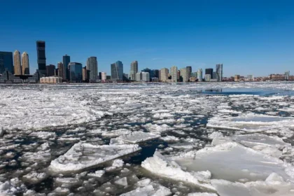 Extreme Cold in New York City Leaves 18 Dead as Temperatures Slowly Rise New York City is recovering after a severe cold wave claimed 18 lives. Officials confirmed that the extreme winter conditions, which began in late January, led to one of the longest freezing streaks the city has seen in decades. Mayor Zohran Mamdani said the city faced 13 straight days of temperatures at or below 0C, a rare event not seen at this scale since 1963. Over the weekend, another person died on the streets, bringing the total number of deaths to 18. He called each loss a tragedy and urged residents to continue looking out for one another. Record Breaking Cold Snap Hits NYC The cold spell started on 19 January when the city announced a Code Blue emergency. This measure allowed homeless shelters to relax intake rules so more people could come inside and stay warm. Since then, officials have placed about 1,400 people into shelters. The city also added 64 hotel rooms to increase shelter space. Outreach teams expanded their efforts as well, with at least 150 additional workers sent onto the streets to assist vulnerable residents. Earlier reports confirmed that at least 10 victims were found outdoors. Authorities have not released full details about the remaining deaths. Although temperatures have started to rise, they remain below seasonal averages. The National Weather Service expects readings to hover around 0C this week. Normally, temperatures reach about 4C during this time of year. Dangerous Wind Chills and Ongoing Risks An Arctic air mass swept across the region over the weekend. It brought intense wind chills that made conditions feel even colder than the actual temperature. These conditions increased the risk of hypothermia and frostbite. While the 13 day freezing streak officially ended on Friday, the danger has not fully passed. Melting snow and ice may fall from rooftops without warning. Streets and sidewalks can refreeze overnight, creating hazardous walking and driving conditions. NYC Emergency Management continues to warn residents to remain cautious. City officials advise people to stay indoors whenever possible and check on elderly neighbors, homeless individuals, and anyone without reliable heating. Mayor Mamdani reminded residents that even 35 degrees Fahrenheit is far from warm. He emphasized that the city will continue working to protect New Yorkers during the remaining cold days.
