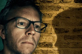 Dark Web Agent Spotted Bedroom Wall Clue to Rescue Girl from Years of Abuse A specialist online investigator uncovered a simple but powerful clue that helped rescue a young girl from years of abuse shared on the dark web. Greg Squire works with the US Department of Homeland Security Investigations in a unit that tracks and identifies children shown in online abuse material. Early in his career, he faced one of the most disturbing cases of his life. His team named the victim Lucy to protect her identity. A Case That Seemed Impossible to Crack Images of Lucy were circulating on hidden online forums. The offender carefully cropped and edited the photos to remove clear identifying details. Investigators could not trace her location or confirm her identity. From visible light sockets and electrical outlets in the background, Squire’s team confirmed that Lucy likely lived in North America. However, that clue was too broad to act on. They contacted Facebook, hoping facial recognition tools could help scan family photos. At the time, the platform said it did not have the tools to assist in that way. The team had to rely on careful visual analysis instead of advanced software. Searching Every Detail in the Room Investigators examined every item in Lucy’s bedroom. They studied her bedspread, clothes, stuffed toys, and furniture. Eventually, they found a small breakthrough. A sofa visible in several images was not sold nationwide. A company had distributed it only in certain regions. That detail reduced the potential customer base to around 40,000 people across 29 US states. Even so, the list remained overwhelming. Then Squire noticed the exposed brick wall in Lucy’s bedroom. The Brick That Changed Everything Squire contacted the Brick Industry Association and asked for help. The organization shared the photo with brick experts across the country. One expert, John Harp, immediately recognized the brick. He had worked in brick sales since 1981. He identified it as a “Flaming Alamo,” a brick produced from the late 1960s to the mid 1980s at a plant in the southwestern United States. Harp explained a critical fact. Bricks are heavy and expensive to transport long distances. Builders usually source them locally. That insight shifted the investigation. The team cross checked the sofa customer list with homes located within 100 miles of the brick factory. The number of potential addresses dropped sharply. Narrowing Down the Suspect From a refined list of about 40 to 50 names, investigators reviewed social media accounts. They found a photo of Lucy with an adult woman who appeared close to her. Authorities traced the woman’s address. They also reviewed other properties linked to her and people she had lived with in the past. The possible locations narrowed even further. Investigators avoided knocking on doors too soon. If they alerted the wrong address, they risked tipping off the suspect. Instead, they sent photos of suspected homes to the brick expert to compare masonry details. A simple brick pattern, hidden in plain sight, helped guide the team toward the right location and ultimately toward Lucy’s rescue.