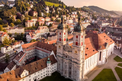 The Abbey Library of St Gallen in eastern Switzerland is a treasure trove of history and knowledge. Its Baroque hall, filled with manuscripts, globes, and unique curiosities, has survived for over 1,300 years, making it one of the world’s oldest and most remarkable libraries. A Journey Back in Time I arrived early in St Gallen when the streets were quiet, and the church bells were still silent. The abbey’s grand stone architecture, with its arched windows, spires, and cloisters, immediately created a sense of awe. Inside, historian Albert Holenstein guided me through echoing corridors to an ornate Baroque doorway. Carved above the entrance was a Greek phrase, "Psyches Iatreion," meaning "healing place of the soul." This ancient inscription hinted at the library’s spiritual and historical significance. A Library of Wonders The library itself is breathtaking. Its intricate wooden bookcases, painted Baroque ceiling, and rows of leather-bound tomes create a scene straight out of a fantasy novel. Terrestrial and celestial globes, Egyptian mummies, and cabinets filled with curiosities from around the world make it feel magical. Items range from silver knives from Turkey to miniature shoes from Indonesia, alongside fossils, shells, and coins. The Abbey Library is more than a collection of religious texts. It houses works on law, music, medicine, astronomy, grammar, arithmetic, rhetoric, and poetry. The abbey served not only as a religious center but also as a hub of education and knowledge, explaining the depth and variety of its collection. Ancient Origins and Rich Heritage The library dates back to the early 7th Century when Irish missionary Saint Gall founded a hermitage that later became the abbey. The current Baroque hall was built in 1767, but the library has preserved its rich heritage. Its collections include 160,000 manuscripts and early printed works, including over 2,100 medieval codices, some written before the year 1000. It also contains the largest collection of Irish manuscripts on mainland Europe, brought by pilgrims traveling to Rome. High German manuscripts in the archive showcase the earliest written examples of the language. Each book tells a story, reflecting the spiritual and intellectual power of written knowledge. Surviving Centuries of Upheaval What makes the Abbey Library of St Gallen truly remarkable is its survival through centuries of political and religious turmoil. Unlike monasteries in England, Wales, and Ireland that were dismantled in the 16th Century, or church properties seized during the French Revolution, St Gallen’s library remained protected. During the abbey’s temporary dissolution between 1797 and 1805, its collections were carefully guarded and preserved by the local Catholic community. Today, the library remains a symbol of learning and history, a place where visitors can experience the wonder of centuries-old manuscripts and treasures.