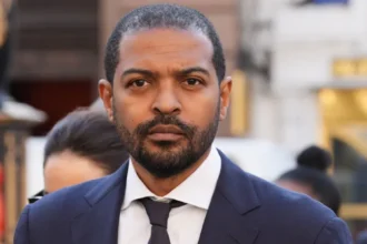 Actor Facing Serious Allegations Noel Clarke, known for his roles in Doctor Who and Kidulthood, has been arrested by the Metropolitan Police. He is suspected of attempted rape, exposure, and sexual assault by touching. The arrest follows an alleged incident that occurred in 2007 in London involving a woman in her 20s. Police Investigation Details Clarke, 50, attended Islington police station by appointment, accompanied by his wife and lawyer. Detectives from the Met’s Central Specialist Crime Command questioned him. He has been released on bail pending further investigation. A spokesperson for the Metropolitan Police confirmed the arrest also involves a voyeurism allegation for which Clarke was previously questioned in September 2025. This earlier allegation concerns an alleged 2013 incident in London involving a woman in her 20s. Career Collapse After Misconduct Allegations Clarke gained fame as Mickey Smith in Doctor Who from 2005 to 2010. He later became a writer, producer, and director. However, his career took a major hit in 2021 after multiple women came forward accusing him of sexual misconduct. Clarke denied the claims at the time. In 2023, Clarke lost a libel case against The Guardian and was ordered to pay at least £3 million of the newspaper’s legal costs. The Guardian estimated its total costs could reach £6 million. Clarke, who represented himself during the hearing, argued that the legal fees were excessive. Public and Industry Reactions The allegations have severely affected Clarke’s reputation in the entertainment industry. His projects have stalled, and he has largely remained out of the public spotlight since the allegations surfaced. The ongoing police investigation could further impact his career depending on the outcome. Next Steps in the Investigation The Metropolitan Police continue their inquiries. Clarke’s bail conditions remain in place while detectives examine both the 2007 and 2013 allegations. Further updates are expected as the investigation progresses.