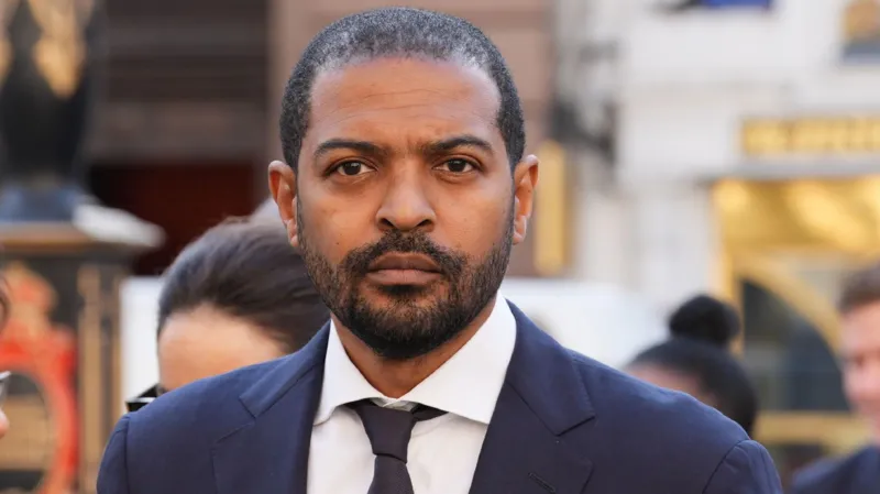 Actor Facing Serious Allegations Noel Clarke, known for his roles in Doctor Who and Kidulthood, has been arrested by the Metropolitan Police. He is suspected of attempted rape, exposure, and sexual assault by touching. The arrest follows an alleged incident that occurred in 2007 in London involving a woman in her 20s. Police Investigation Details Clarke, 50, attended Islington police station by appointment, accompanied by his wife and lawyer. Detectives from the Met’s Central Specialist Crime Command questioned him. He has been released on bail pending further investigation. A spokesperson for the Metropolitan Police confirmed the arrest also involves a voyeurism allegation for which Clarke was previously questioned in September 2025. This earlier allegation concerns an alleged 2013 incident in London involving a woman in her 20s. Career Collapse After Misconduct Allegations Clarke gained fame as Mickey Smith in Doctor Who from 2005 to 2010. He later became a writer, producer, and director. However, his career took a major hit in 2021 after multiple women came forward accusing him of sexual misconduct. Clarke denied the claims at the time. In 2023, Clarke lost a libel case against The Guardian and was ordered to pay at least £3 million of the newspaper’s legal costs. The Guardian estimated its total costs could reach £6 million. Clarke, who represented himself during the hearing, argued that the legal fees were excessive. Public and Industry Reactions The allegations have severely affected Clarke’s reputation in the entertainment industry. His projects have stalled, and he has largely remained out of the public spotlight since the allegations surfaced. The ongoing police investigation could further impact his career depending on the outcome. Next Steps in the Investigation The Metropolitan Police continue their inquiries. Clarke’s bail conditions remain in place while detectives examine both the 2007 and 2013 allegations. Further updates are expected as the investigation progresses.