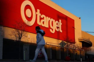 Target Cuts 500 Jobs as It Refocuses on Store Growth Target has announced it will cut around 500 jobs across its regional offices and distribution centers in the United States. The company says this move will help it invest more money and resources directly into its stores. Executives shared the decision with employees through an internal email on Monday. The company believes these changes will allow it to strengthen store operations and attract more customers. Reorganization Aims to Boost Store Staffing Along with the job cuts, Target is reorganizing its geographic store districts. Leaders say this step will free up resources so the company can increase staffing levels in stores where support is needed most. Management plans to add more labor hours and provide new training focused on improving the overall guest experience. Company leaders say enhancing in store service remains a top priority for future growth. New CEO Begins Strategic Changes These changes mark one of the first major decisions by Target’s new chief executive, Michael Fiddelke. He took over leadership last year as the retailer struggled with stagnant sales that have lasted more than four years. The latest cuts follow an earlier round of layoffs announced in October. At that time, Target eliminated about 1,800 corporate positions, which represented roughly eight percent of its global corporate workforce. Although this round is smaller, it shows that the company continues to shift investments away from corporate roles and toward store level improvements. Retail Challenges Continue Target has long built its brand on affordable fashion, groceries, home products, electronics, and toys. However, recent economic pressure has changed customer spending habits. Many shoppers now limit purchases to essentials and avoid non essential items such as clothing and electronics. These categories make up nearly half of Target’s total sales. The company has also dealt with supply chain shortages and public criticism over its decision to end diversity, equity, and inclusion targets. In addition, recent immigration enforcement actions in Minneapolis created internal tension. Last month, authorities detained two workers inside a suburban Minneapolis Target store. After the incident, more than 300 employees signed a letter urging company leaders to take action and address concerns about enforcement activity on store property. A Push to Win Back Customers Target now hopes that stronger store staffing, better training, and improved customer service will help rebuild momentum. Leadership believes that investing directly in stores can restore growth and bring shoppers back through the doors. The company has not yet shared full details about how much it plans to invest in store improvements. However, the direction is clear. Target wants to strengthen the in store experience as competition in retail continues to grow.