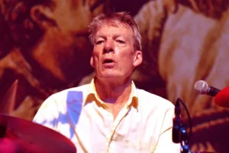 Pogues Drummer Andrew Ranken Dies at 72 The Pogues have announced the death of their drummer, Andrew Ranken, at the age of 72. Ranken, a founding member of the London-based band, was an integral part of some of their most famous songs, including Fairytale of New York and Dirty Old Town. A Tribute to the Heartbeat of The Pogues The band shared a heartfelt statement online, remembering Ranken as the "heartbeat of The Pogues". They added, "Andrew, thank you for everything, for your friendship, your wit, and your generosity of spirit, and of course for the music. Forever a true friend and brother." Career and Musical Legacy Nicknamed "The Clobberer," Ranken was not just the drummer. He also played percussion, harmonica, and contributed vocals during the 1990s and 2000s. His versatility helped shape the distinctive sound of The Pogues. Formed in 1982, The Pogues became one of London’s most iconic music groups. The classic lineup included the late singer Shane MacGowan, bassist Cait O'Riordan, tin whistle player Spider Stacy, banjo player Jem Finer, and accordionist James Fearnley. Together, they created a unique blend of punk and traditional Irish music that captivated audiences worldwide. Remembering Andrew Ranken Fans and fellow musicians have expressed their sorrow at the news. Ranken’s contributions to music extended beyond drumming. His energy, humor, and generous spirit left a lasting mark on everyone he worked with. Though Ranken has passed, his music and legacy continue to inspire new generations of musicians and Pogues fans around the world.