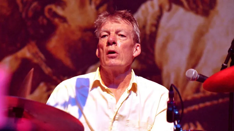 Pogues Drummer Andrew Ranken Dies at 72 The Pogues have announced the death of their drummer, Andrew Ranken, at the age of 72. Ranken, a founding member of the London-based band, was an integral part of some of their most famous songs, including Fairytale of New York and Dirty Old Town. A Tribute to the Heartbeat of The Pogues The band shared a heartfelt statement online, remembering Ranken as the "heartbeat of The Pogues". They added, "Andrew, thank you for everything, for your friendship, your wit, and your generosity of spirit, and of course for the music. Forever a true friend and brother." Career and Musical Legacy Nicknamed "The Clobberer," Ranken was not just the drummer. He also played percussion, harmonica, and contributed vocals during the 1990s and 2000s. His versatility helped shape the distinctive sound of The Pogues. Formed in 1982, The Pogues became one of London’s most iconic music groups. The classic lineup included the late singer Shane MacGowan, bassist Cait O'Riordan, tin whistle player Spider Stacy, banjo player Jem Finer, and accordionist James Fearnley. Together, they created a unique blend of punk and traditional Irish music that captivated audiences worldwide. Remembering Andrew Ranken Fans and fellow musicians have expressed their sorrow at the news. Ranken’s contributions to music extended beyond drumming. His energy, humor, and generous spirit left a lasting mark on everyone he worked with. Though Ranken has passed, his music and legacy continue to inspire new generations of musicians and Pogues fans around the world.