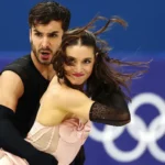 France Ice Dance Controversy: Gold at Stake Amid Rivalry and Drama The ice dance event at Milan Cortina 2026 is heading toward a dramatic finish. Two elite teams are fighting for Olympic gold, and the margin between them is razor thin. American duo Madison Chock and Evan Bates sit in second place. The married pair already won gold in the team event and hold three world titles. They have skated together since 2011 and bring years of chemistry to the ice. Just 0.46 points ahead are France’s Guillaume Cizeron and Laurence Fournier Beaudry. They teamed up only last November, yet they have already made a huge impact. Cizeron, the reigning Olympic champion, aims to win back to back titles. A New Partnership, Instant Results Cizeron won Olympic gold at Beijing 2022 with Gabriella Papadakis. After their split, he formed a new partnership with Fournier Beaudry. The decision raised eyebrows, but the results speak loudly. The French pair delivered a technically sharp rhythm dance to Madonna’s Vogue. Judges awarded them a stronger technical score on their step sequence than the Americans. That edge gave them the slim lead. Since joining forces, they have won four of five major events. One of those victories came at the 2026 European Championship in Sheffield. Their only loss happened at the Grand Prix Final, where Chock and Bates beat them. The final medals will depend on the free dance. Unlike the rhythm dance, the free program gives skaters more creative control. Both segments combined will decide the champion. Judging Debate Adds More Tension Figure skating judging has sparked debate for decades. Ice dance relies on both technical elements and artistic interpretation. Even small scoring differences can decide medals. This time, less than half a point separates gold from silver. That tiny gap keeps fans guessing. Fallout From a Bitter Split The drama off the ice rivals the competition itself. Cizeron’s former partner, Gabriella Papadakis, released a memoir earlier this year. In it, she described their partnership as unbalanced. She said she felt controlled and pressured during their years together. Cizeron strongly denied the claims. He called the book a smear campaign and said it spreads false information. He has started legal action in response. The situation also affected Papadakis professionally. NBC removed her from its Olympic analyst role, citing a conflict of interest linked to her memoir. Citizenship Change and Fresh Controversy Fournier Beaudry’s journey to Team France also stirred debate. She previously competed for Canada and Denmark. France granted her citizenship in November so she could skate with Cizeron at the Games. Before this partnership, she skated with Canadian athlete Nikolaj Sorensen, who is also her partner in real life. In 2025, officials handed Sorensen a six year suspension after a sexual assault allegation dating back to 2012. The case involves an American skating coach. It does not involve Fournier Beaudry. Sorensen denies the allegation and calls it false. Fournier Beaudry has publicly supported him. In a Netflix documentary, she said she fully trusts him. The anonymous complainant criticized her comments. The accuser argued that such statements could discourage others from reporting abuse. Since gaining French citizenship, Fournier Beaudry has declined further comment on the issue. All Eyes on the Free Dance Now, the focus returns to the ice. Cizeron and Fournier Beaudry hold a narrow lead. Chock and Bates bring experience and consistency. The free dance will test not only skill but also nerve. One small mistake could change everything. At Milan Cortina 2026, the battle for gold carries more than medals. It carries history, rivalry, and controversy that has followed these skaters all the way to the Olympic stage.