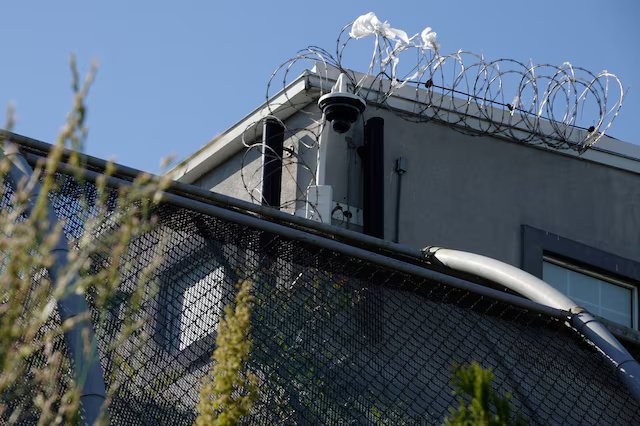 Exterior view of a GEO Group ICE detention facility amid human rights debate
