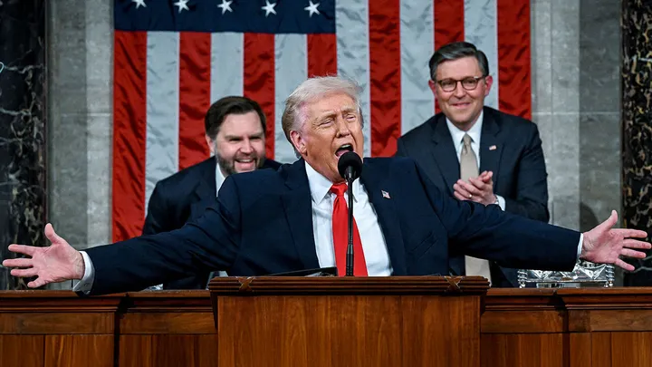 President Donald Trump speaking during his record breaking State of the Union address as Nancy Pelosi reacts