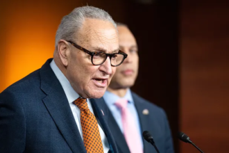 Senator John Thune speaks at a podium with the U.S. Capitol behind him
