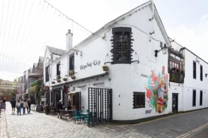 Alasdair Gray Murals on Ubiquitous chip Gain Protected Statute The Ubiquitous chip, one of Glasgow's iconic restaurants, was granted listed building status. This recognition is mainly due to the unique murals painted by the celebrated Scottish artist Alasdair Grey. Historic Environment Scotland officially classifies the building as Category B. The murals in the restaurant are of cultural and artistic importance, as a result. Glasgow Murals that Capture the Creative Spirit Alasdair Grey painted the murals in the early and late 1980s. He was a frequent visitor at the time. In exchange for food and hospitality, he created the art. In the era of that mural, Florid jungle and Arcadia are two rare public works. The vibrant cultural scene in Glasgow's West End is reflected by these works. These works also reflect Gray's strong connection to the local art community. Arcadia shows a group in a garden. This mural features real people from the local community to add a more personal touch. Florid jungle is a colorful and dense natural scene that appears in the courtyard of the restaurant. Cultural Landmarks with Rich History The Ubiquitous chip first opened its doors in 1971. It moved to Ashton Lane, in 1974. The former stables, livery yards and other uses of the building are still evident. It became an important part of Glasgow’s cultural and dining life over time. It was the restaurant that introduced fine Scottish cuisine to the city. The restaurant became a meeting place for writers, artists and performers. Over the years, many well-known people have dined at the restaurant. They include Princess Margaret and Mick Jagger. Greene King purchased the restaurant in 2022 after more than 50-years of family ownership. Gray's Lasting Artistic Legacy Alasdair Grey was born in Glasgow. He became one of Scotland’s most important cultural figures. His work encompassed many different fields including painting, writing and printing. Lanark, his famous novel in Scottish Literature, remains an important landmark. Gray was adamant about bringing art to public places. Gray's work can be found in galleries, pubs, churches and parks all over the city. His work is also on display at the V&A Dundee, and the Scottish National Gallery of Modern Art. Oran Mor is located close to the Ubiquitous Chip. In 2012, a large mural was painted at Hillhead Subway Station. Recognizing the Importance of Public Art Gray, according to experts, wanted to make art available to all. He combines visual art, literature and social concepts in his work. These murals are now protected for future generations. The listing status confirms the importance of these murals in Scotland's culture.