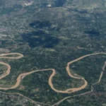 Haiti Gang Attack Leaves Dead and Thousands Displaced Coordinated Violence in Rural Haiti At least 16 people have died in a series of violent attacks in rural Haiti over the weekend. Authorities report that armed groups targeted communities in the central Artibonite region, forcing thousands of residents to flee for safety. Local reports suggest the death toll could be higher, with some estimates reaching up to 70. Police are still working to access the affected area, where gang members continue to operate freely. Attacks in Jean Denis Area The violence began early Sunday in the Jean Denis area near Petite Riviere de l Artibonite. Witnesses said armed attackers arrived from multiple directions, setting homes on fire and shooting at people trying to escape. By the next morning, survivors found bodies scattered along the roads. A second wave of attacks followed on Monday, increasing fear among residents. Rising Casualties and Displacement So far, 16 bodies have been taken to local morgues. However, ongoing insecurity has prevented many families from recovering their loved ones. Officials also reported at least 19 injured people, while local activists estimate that around 6,000 residents have left their homes due to the violence. Role of the Gran Grif Gang Authorities and rights groups blame the Gran Grif gang for the attacks. This group is known as one of the most dangerous criminal networks in Haiti. The gang has been linked to past large scale violence in the region. In 2024, it carried out attacks in Pont Sondé that killed over 100 people. At least 16 killed and thousands displaced by gang attack in rural Haiti Security Challenges in Haiti Security forces and international police units deployed to Haiti continue to struggle against heavily armed gangs. These groups often control certain areas, making it difficult for authorities to intervene. Experts say the recent attack appeared well planned, with blocked roads and coordinated movements that limited police response. There are also concerns about shifting loyalties within local armed groups. Some leaders who once protected communities have reportedly joined criminal gangs, increasing instability and confusion on the ground.