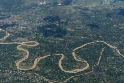 Haiti Gang Attack Leaves Dead and Thousands Displaced Coordinated Violence in Rural Haiti At least 16 people have died in a series of violent attacks in rural Haiti over the weekend. Authorities report that armed groups targeted communities in the central Artibonite region, forcing thousands of residents to flee for safety. Local reports suggest the death toll could be higher, with some estimates reaching up to 70. Police are still working to access the affected area, where gang members continue to operate freely. Attacks in Jean Denis Area The violence began early Sunday in the Jean Denis area near Petite Riviere de l Artibonite. Witnesses said armed attackers arrived from multiple directions, setting homes on fire and shooting at people trying to escape. By the next morning, survivors found bodies scattered along the roads. A second wave of attacks followed on Monday, increasing fear among residents. Rising Casualties and Displacement So far, 16 bodies have been taken to local morgues. However, ongoing insecurity has prevented many families from recovering their loved ones. Officials also reported at least 19 injured people, while local activists estimate that around 6,000 residents have left their homes due to the violence. Role of the Gran Grif Gang Authorities and rights groups blame the Gran Grif gang for the attacks. This group is known as one of the most dangerous criminal networks in Haiti. The gang has been linked to past large scale violence in the region. In 2024, it carried out attacks in Pont Sondé that killed over 100 people. At least 16 killed and thousands displaced by gang attack in rural Haiti Security Challenges in Haiti Security forces and international police units deployed to Haiti continue to struggle against heavily armed gangs. These groups often control certain areas, making it difficult for authorities to intervene. Experts say the recent attack appeared well planned, with blocked roads and coordinated movements that limited police response. There are also concerns about shifting loyalties within local armed groups. Some leaders who once protected communities have reportedly joined criminal gangs, increasing instability and confusion on the ground.