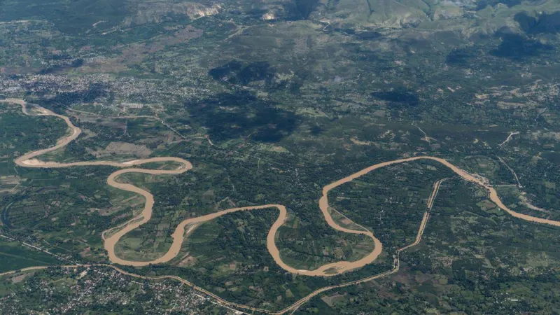 Haiti Gang Attack Leaves Dead and Thousands Displaced Coordinated Violence in Rural Haiti At least 16 people have died in a series of violent attacks in rural Haiti over the weekend. Authorities report that armed groups targeted communities in the central Artibonite region, forcing thousands of residents to flee for safety. Local reports suggest the death toll could be higher, with some estimates reaching up to 70. Police are still working to access the affected area, where gang members continue to operate freely. Attacks in Jean Denis Area The violence began early Sunday in the Jean Denis area near Petite Riviere de l Artibonite. Witnesses said armed attackers arrived from multiple directions, setting homes on fire and shooting at people trying to escape. By the next morning, survivors found bodies scattered along the roads. A second wave of attacks followed on Monday, increasing fear among residents. Rising Casualties and Displacement So far, 16 bodies have been taken to local morgues. However, ongoing insecurity has prevented many families from recovering their loved ones. Officials also reported at least 19 injured people, while local activists estimate that around 6,000 residents have left their homes due to the violence. Role of the Gran Grif Gang Authorities and rights groups blame the Gran Grif gang for the attacks. This group is known as one of the most dangerous criminal networks in Haiti. The gang has been linked to past large scale violence in the region. In 2024, it carried out attacks in Pont Sondé that killed over 100 people. At least 16 killed and thousands displaced by gang attack in rural Haiti Security Challenges in Haiti Security forces and international police units deployed to Haiti continue to struggle against heavily armed gangs. These groups often control certain areas, making it difficult for authorities to intervene. Experts say the recent attack appeared well planned, with blocked roads and coordinated movements that limited police response. There are also concerns about shifting loyalties within local armed groups. Some leaders who once protected communities have reportedly joined criminal gangs, increasing instability and confusion on the ground.