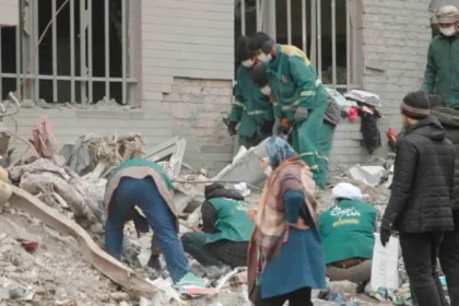 Airstrikes in Tehran trap civilians as they strike residential areas Airstrikes in Tehran have caused a wave of destruction, with families and civilians being buried beneath rubble. Although intended to target military targets, the attacks also affected residential areas. This raises serious questions about civilian safety. Waiting for a Mother Turns into Tragedy A mother in the Resalat neighborhood stood helpless next to the ruin of the apartment her daughter had occupied. She waited for days as rescuers struggled to find those who were trapped under the debris. She repeated that her daughter was alive and well under the rubble, but she was afraid of darkness. The rescue operation was slowed by a lack of manpower. Both the young daughter and mother were later found to be dead. Although the husband was still alive, the death of the daughter and her child devastated the entire family. There is widespread damage in residential zones In seconds, the strike on Resalat destroyed a number of buildings. The Basij is a paramilitary organization associated with the Islamic Revolutionary Guard Corps. Apartment blocks nearby were also destroyed. Satellite and aerial footage shows that four buildings have collapsed. The homes located as far away as 65 meters suffered severe damage. Residents reported hearing multiple explosions in seconds. This suggests that repeated attacks were made within a short period of time. A survivor remembered being thrown around the room. His home, personal items, and documents were all destroyed. After losing their homes, many families are now forced to seek shelter in hotels nearby. The Civilian Death toll is on the Rise According to local sources, this strike killed between 40-50 people. Many of the victims were civilians with no connection to military activities. The attacks were part of a conflict that has been ongoing between Iran, Israel, and the United States. The strikes are aimed at targets linked to the state, but their location in civilian areas increases the danger for non-combatants. The use of powerful bombs raises concerns Analysts believe large bombs, such as the Mark 84 and Mark 80, from the Mark 80 family were used. The weapons have a high impact and explosive power, even if they are guided by precision systems. This assessment is supported by the scale of destruction at Resalat. The entire structure was reduced to rubble and the shockwaves caused damage in surrounding buildings. Civilians caught between conflict and control Now, residents are facing a double-edged sword. One side is the constant airstrikes. They are also under tight internal control after recent crackdowns against protestors. There is a sense of helplessness among many, who have limited or no access to support and safety. The humanitarian costs are increasing as the conflict progresses, particularly in urbanized areas.