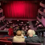 Theatre Plans Job Cuts to Secure Long-Term Sustainability A well-known theatre has announced plans to reduce staff as part of a strategy to stay financially stable in a difficult economic climate. Reports suggest that around 19 roles could be affected, mainly in the sales and box office departments. The management has not confirmed the exact number of job losses. However, local sources indicate that the cuts will focus on operational teams that handle ticketing and customer services. Rising Costs Force Tough Decisions The theatre explained that it is facing increasing financial pressure. Like many cultural organisations, it is dealing with reduced funding and higher expenses. Leaders pointed to rising production costs and building maintenance expenses. Inflation has made it more expensive to run shows and manage the venue. These challenges pushed the organisation to review its spending and make necessary changes. Focus on Long-Term Stability According to the theatre’s statement, the decision is part of a careful plan. The goal is to protect its future while continuing to deliver quality performances. The management said it wants to keep ticket prices affordable. At the same time, it aims to maintain a strong artistic programme. Balancing these priorities has become harder due to financial strain. Support for Affected Staff The theatre acknowledged that job losses will impact employees. It described this period as difficult for staff members who may lose their roles. Officials said they will support employees throughout the process. They plan to offer guidance and assistance during the transition. About the Venue The theatre complex includes two main performance spaces. The Derngate auditorium can seat around 1,500 people. The Royal theatre has a smaller capacity of about 450 seats. Theatre to cut jobs to ensure its 'sustainability'