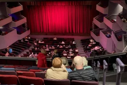 Theatre Plans Job Cuts to Secure Long-Term Sustainability A well-known theatre has announced plans to reduce staff as part of a strategy to stay financially stable in a difficult economic climate. Reports suggest that around 19 roles could be affected, mainly in the sales and box office departments. The management has not confirmed the exact number of job losses. However, local sources indicate that the cuts will focus on operational teams that handle ticketing and customer services. Rising Costs Force Tough Decisions The theatre explained that it is facing increasing financial pressure. Like many cultural organisations, it is dealing with reduced funding and higher expenses. Leaders pointed to rising production costs and building maintenance expenses. Inflation has made it more expensive to run shows and manage the venue. These challenges pushed the organisation to review its spending and make necessary changes. Focus on Long-Term Stability According to the theatre’s statement, the decision is part of a careful plan. The goal is to protect its future while continuing to deliver quality performances. The management said it wants to keep ticket prices affordable. At the same time, it aims to maintain a strong artistic programme. Balancing these priorities has become harder due to financial strain. Support for Affected Staff The theatre acknowledged that job losses will impact employees. It described this period as difficult for staff members who may lose their roles. Officials said they will support employees throughout the process. They plan to offer guidance and assistance during the transition. About the Venue The theatre complex includes two main performance spaces. The Derngate auditorium can seat around 1,500 people. The Royal theatre has a smaller capacity of about 450 seats. Theatre to cut jobs to ensure its 'sustainability'