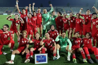 Afghanistan Women Football Team Returns to International Stage After FIFA Decision FIFA Approves Return Under Special Rules FIFA has approved a new rule that allows Afghanistan women footballers to return to international competition under special circumstances. The decision enables players to represent their country even when their national federation cannot officially support a team. This change follows years of restrictions after the Taliban took control of Afghanistan in 2021. Women were banned from sports, and many footballers left the country to seek safety abroad. Players Forced Into Exile After 2021 Afghanistan women last played an official match in 2018. After 2021, women faced strict limits on sport and public participation. Many national team players relocated to countries such as Australia, the United States, Europe, and the Middle East. More than 80 Afghan women footballers now live outside Afghanistan. Some were under contract before the political change, while others joined later as refugees. Formation of Afghan Women United FIFA supported a refugee team called Afghan Women United in 2025 as part of a pilot program. This team gave displaced players a platform to compete and stay active in international football. The team has already played friendly matches. It recorded its first win against Libya during the FIFA United Women Series in 2025. New Pathway for International Matches The updated FIFA rule allows a national or representative team to compete even when the member federation cannot officially register it. This ensures players are not blocked from football due to political or external conditions. Afghanistan will not take part in the 2027 Women's World Cup. However, the team may join qualification matches for the 2028 Olympics. Their return to international fixtures is expected in June. Leadership and Player Response Former captain Khalida Popal welcomed the decision and said the team represents strength and hope for Afghan women. She highlighted that players inside Afghanistan still face major restrictions. She said the team will continue to speak for those who cannot leave the country and will support young players in exile communities. Training and Preparation Plans FIFA has organized regional selection camps in England and Australia. A training camp in New Zealand is also planned for June. These camps will help prepare the squad for upcoming international matches.