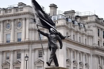 Banksy confirms a new statue in central London at Waterloo Place, showing a suited man with a covered face, placed near historic monuments.