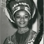 Cynthia Shange, South Africa’s Miss World Pioneer, Dies at Seventy Six Early life and rise to recognition Cynthia Philisiwe Shange was born on twenty seven July nineteen forty nine. She grew up during apartheid in South Africa, a system that restricted opportunities for Black citizens. Despite these barriers, she built a path into public life through beauty pageants and later acting. Breaking barriers in beauty pageants Shange gained national attention after winning Miss Africa South, a contest created because Black women were not allowed to enter Miss South Africa at the time. This achievement opened the door for her to compete internationally. In nineteen seventy two, she represented South Africa at the Miss World competition in London. She stood on the global stage during a period when apartheid shaped every aspect of her country’s identity. She finished in fifth place, making history as the first Black woman to represent South Africa at Miss World. Earlier challenges in the pageant system Before Shange’s participation, Pearl Gladys Jansen also competed internationally as Miss Africa South in nineteen seventy. Her entry caused controversy and highlighted the racial inequalities within global pageants during that era. Acting career and public life After her pageant success, Shange built a long acting career. She appeared in several productions over the years and became known for her strong screen presence. Her work helped expand her influence beyond pageantry into South African entertainment. Death and family tribute Shange passed away in hospital early Monday morning after an illness. She was seventy six years old. Her daughter, Nonhle Thema, confirmed the news and paid tribute to her mother. She described her as a compassionate and graceful woman who brought warmth and kindness to those around her. She also asked for privacy and prayers for the family during this difficult time. Funeral details have not yet been shared. Legacy Cynthia Shange is remembered as a trailblazer who challenged racial barriers during apartheid. Her journey through international pageantry and acting left a lasting mark on South African cultural history.