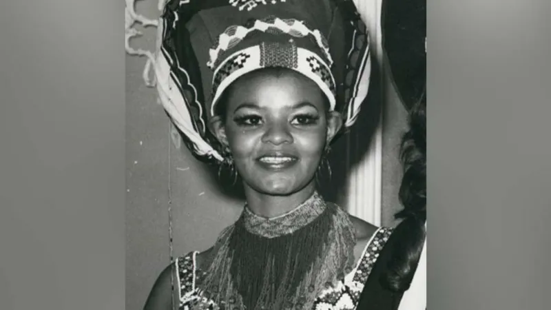 Cynthia Shange, South Africa’s Miss World Pioneer, Dies at Seventy Six Early life and rise to recognition Cynthia Philisiwe Shange was born on twenty seven July nineteen forty nine. She grew up during apartheid in South Africa, a system that restricted opportunities for Black citizens. Despite these barriers, she built a path into public life through beauty pageants and later acting. Breaking barriers in beauty pageants Shange gained national attention after winning Miss Africa South, a contest created because Black women were not allowed to enter Miss South Africa at the time. This achievement opened the door for her to compete internationally. In nineteen seventy two, she represented South Africa at the Miss World competition in London. She stood on the global stage during a period when apartheid shaped every aspect of her country’s identity. She finished in fifth place, making history as the first Black woman to represent South Africa at Miss World. Earlier challenges in the pageant system Before Shange’s participation, Pearl Gladys Jansen also competed internationally as Miss Africa South in nineteen seventy. Her entry caused controversy and highlighted the racial inequalities within global pageants during that era. Acting career and public life After her pageant success, Shange built a long acting career. She appeared in several productions over the years and became known for her strong screen presence. Her work helped expand her influence beyond pageantry into South African entertainment. Death and family tribute Shange passed away in hospital early Monday morning after an illness. She was seventy six years old. Her daughter, Nonhle Thema, confirmed the news and paid tribute to her mother. She described her as a compassionate and graceful woman who brought warmth and kindness to those around her. She also asked for privacy and prayers for the family during this difficult time. Funeral details have not yet been shared. Legacy Cynthia Shange is remembered as a trailblazer who challenged racial barriers during apartheid. Her journey through international pageantry and acting left a lasting mark on South African cultural history.