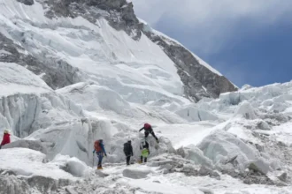 A massive glacier block is delaying Everest climbs as teams wait for a safe route to open during peak season.
