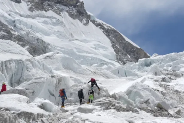 A massive glacier block is delaying Everest climbs as teams wait for a safe route to open during peak season.