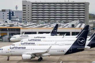 Lufthansa Cuts 20,000 Flights as Fuel Prices Surge Rising Fuel Costs Force Major Flight Reductions Lufthansa has announced it will cancel around 20,000 short-haul flights this summer. The airline says rising fuel prices have made many routes too expensive to operate. Jet fuel prices have sharply increased since the start of the conflict involving the US, Israel, and Iran. The situation has slowed production and disrupted supply routes across the Middle East. Airlines Pass Costs to Travelers Other major airlines, including Air France–KLM and Delta Air Lines, have also reduced some flights. At the same time, many carriers have raised ticket prices to cover higher costs. Industry experts warn that ticket prices may continue to rise. Travelers could also face more cancellations if the situation does not improve. Middle East Supply Disruptions Impact Europe The Middle East plays a key role in global jet fuel supply. It provides about half of Europe’s aviation fuel imports. Much of this supply passes through the Strait of Hormuz. Iran has restricted access to this route in response to recent military actions. This has caused delays and reduced fuel availability. The International Energy Agency recently warned that Europe could face jet fuel shortages within weeks. However, UK officials and airlines say they have not yet seen major supply disruptions. Lufthansa Adjusts Network Strategy Lufthansa confirmed it will scale down its European routes. However, it will continue to operate long-haul international flights. The airline said this move will improve efficiency and reduce fuel use. It expects to save around 40,000 metric tons of jet fuel. Fleet Changes and Route Cuts The airline has also decided to speed up the closure of its CityLine operations. It plans to retire 27 aircraft as part of this move. Lufthansa said higher fuel costs and ongoing labor issues influenced this decision. Some of the first route cuts have already started. These include flights from Frankfurt to cities in Poland and Norway.