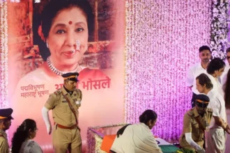 Asha Bhosle cremation: India bids emotional farewell to iconic singer Asha Bhosle, the legendary Indian singer who died at age 92 on Sunday was buried in Mumbai one day later. Shivaji Park was the site of her cremation with all state honors. Many fans, politicians, and celebrities gathered in Shivaji Park to show their respects. As her funeral procession slowly moved through the city, crowds lined streets and stood up on roofs. The Music of My Life Asha Bhosle had a career that spanned nearly 80 years. She has recorded thousands of tracks in many languages and styles. Her voice has influenced Indian cinema, and generations of artists. After suffering from a cardiac arrest, she passed away on Sunday in Mumbai. Thousands of her fans came to her house after her death to express their condolences. Before the last rites, her body was wrapped in an Indian flag in a casket surrounded with flowers. A Farewell Song with Iconic Emotion In the final moments of her funeral, people began to sing her song "Abhi Na Jaao Chhor Kar." This emotional tribute showed how deeply connected they were with her music. As part of her state honours, she also received a formal gun salute. Tributes by Leaders and Celebrities Narendra Modi, the Indian prime minister, described her as having one of the best voices India has ever heard. Droupadi murmu, the president of India, called her death a loss irreparable for music fans. Shah Rukh Khan, Bollywood star and singer said that her music would inspire generations to come. Sachin Tendulkar, cricket legend and former world number one said that her songs would continue to inspire people for generations. Honored Beyond Music Asha Bhosle, a passionate cricket enthusiast, was honored during an Indian Premier League game. Asha Bhosle was also honored during an Indian Premier League match.