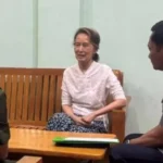 Myanmar’s military says Aung San Suu Kyi has been moved from prison to house arrest after a sentence adjustment.
