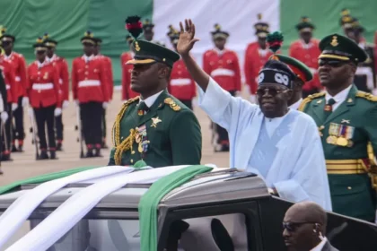 Nigeria charges six people in alleged Independence Day coup plot Background of the alleged coup case Authorities in Nigeria have filed treason charges against six individuals over an alleged plot linked to the country’s Independence Day events. The case connects to concerns that first appeared in October 2025 when officials suddenly cancelled a planned military parade for Nigeria’s 65th Independence Anniversary. Government officials explained the cancellation as a response to security risks. However, public discussion quickly shifted toward speculation about a possible coup attempt. The military later rejected those claims. In January, it confirmed that 16 officers would face a military trial for allegedly trying to remove the president from power. Federal court expands criminal charges Separate proceedings have now moved to the Federal High Court. Prosecutors have added charges of terrorism and financial crimes alongside treason. It remains unclear whether these new charges run alongside the ongoing military trials or form part of the same investigation. Key individuals named in the case Among those charged is former petroleum minister Timipre Sylva, who also previously served as governor of Bayelsa State. Investigators searched his residence in October, but he has denied any involvement in a coup plan. Another defendant is Abdulkadir Sani, an Islamic cleric. Court documents list all six accused as having conspired to wage war against the state with the aim of overpowering the president. Authorities allege that Col Mohammed Alhassan Ma’aji led the attempted plan. He was arrested along with other suspects. Allegations of support and funding Prosecutors claim the accused had prior awareness of Ma’aji’s alleged treason activities but failed to alert security agencies. The charge sheet also accuses them of withholding intelligence that could have prevented serious security threats. Financial crime allegations form a major part of the case. Investigators say funds moved between the accused in ways linked to terrorism financing and efforts to destabilize the government. Case status All six defendants have not publicly responded to the charges. The court proceedings continue as authorities pursue both security related and financial crime allegations.