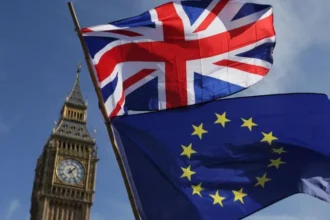 Keir Starmer Pushes Closer UK EU Cooperation Amid Brexit Tensions UK moves toward tighter alignment with EU rules Prime Minister Keir Starmer is pushing for a closer working relationship with the European Union, following commitments first outlined during the 2024 general election. The plan includes ongoing talks between the UK and EU on food and drink standards, carbon emissions, and electricity cooperation. A key part of the proposal is “dynamic alignment.” This would mean the UK not only matches current EU rules in selected areas but also continues updating its regulations as EU laws evolve. Parliament role and concerns over oversight The government plans to bring legislation forward later this year. MPs will vote on the main framework. After that, many future changes could be handled through secondary legislation. That approach has raised concerns among opposition parties. Critics argue it reduces direct parliamentary scrutiny over rule changes that follow EU updates. Political backlash over sovereignty Conservative and Reform UK leaders strongly oppose the plan. Andrew Griffith, the shadow business secretary, warned it could turn Parliament into a passive body while EU rules shape UK policy. Nigel Farage also criticised the approach, saying it allows rule adoption without real influence over decision making. He described it as a reversal of the Brexit referendum outcome. Supporters of the policy argue that targeted alignment could improve trade efficiency and economic stability, even if it limits independent rule making in certain sectors. Starmer links policy to global instability Starmer has framed the shift as a response to rising global uncertainty. He argues that closer cooperation with Europe strengthens the UK position in an unstable world. He has also suggested that Brexit has harmed economic performance and that deeper cooperation could help repair some of that damage. Political strategy and shifting debate The issue was once handled cautiously by Labour leadership due to concerns about voter sensitivity on Brexit. However, changing public opinion and growing political pressure have made the topic more prominent. Recent polling suggests Brexit is less popular than in previous years. At the same time, Labour is facing pressure from progressive voters who want stronger ties with Europe. Limits of the current approach Despite the new direction, the government is not proposing a return to the single market or customs union. That means the UK would not reintroduce free movement of people or abandon its independent trade agreements. This middle path is likely to keep the debate active within both Parliament and the Labour Party.