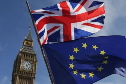 Keir Starmer Pushes Closer UK EU Cooperation Amid Brexit Tensions UK moves toward tighter alignment with EU rules Prime Minister Keir Starmer is pushing for a closer working relationship with the European Union, following commitments first outlined during the 2024 general election. The plan includes ongoing talks between the UK and EU on food and drink standards, carbon emissions, and electricity cooperation. A key part of the proposal is “dynamic alignment.” This would mean the UK not only matches current EU rules in selected areas but also continues updating its regulations as EU laws evolve. Parliament role and concerns over oversight The government plans to bring legislation forward later this year. MPs will vote on the main framework. After that, many future changes could be handled through secondary legislation. That approach has raised concerns among opposition parties. Critics argue it reduces direct parliamentary scrutiny over rule changes that follow EU updates. Political backlash over sovereignty Conservative and Reform UK leaders strongly oppose the plan. Andrew Griffith, the shadow business secretary, warned it could turn Parliament into a passive body while EU rules shape UK policy. Nigel Farage also criticised the approach, saying it allows rule adoption without real influence over decision making. He described it as a reversal of the Brexit referendum outcome. Supporters of the policy argue that targeted alignment could improve trade efficiency and economic stability, even if it limits independent rule making in certain sectors. Starmer links policy to global instability Starmer has framed the shift as a response to rising global uncertainty. He argues that closer cooperation with Europe strengthens the UK position in an unstable world. He has also suggested that Brexit has harmed economic performance and that deeper cooperation could help repair some of that damage. Political strategy and shifting debate The issue was once handled cautiously by Labour leadership due to concerns about voter sensitivity on Brexit. However, changing public opinion and growing political pressure have made the topic more prominent. Recent polling suggests Brexit is less popular than in previous years. At the same time, Labour is facing pressure from progressive voters who want stronger ties with Europe. Limits of the current approach Despite the new direction, the government is not proposing a return to the single market or customs union. That means the UK would not reintroduce free movement of people or abandon its independent trade agreements. This middle path is likely to keep the debate active within both Parliament and the Labour Party.