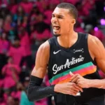 Wembanyama Makes NBA History With Unanimous Defensive Player of the Year Win Historic NBA Defensive Award for Wembanyama Victor Wembanyama of the San Antonio Spurs has won the NBA Defensive Player of the Year award in a historic sweep. Every voter selected him for first place, making him the first player ever to win the award unanimously in its 43 year history. At age 22, he also becomes the youngest player to earn this honor. He is only the second player to win it within his first three NBA seasons, following Spurs legend David Robinson. Wembanyama said he felt proud and very happy, especially about the unanimous support from voters. Dominant Season on Both Ends of the Court Wembanyama led the league in blocks for a third straight season with an average of 3.1 per game. He also posted career highs in scoring at 25 points per game and 11.5 rebounds per game. He added one steal per game, showing strong all around defensive impact. His presence changed how teams attacked the basket. Many opponents avoided the paint when he was on the court because of his shot blocking ability. German basketball legend Dirk Nowitzki praised his impact, saying he has never seen a defender who alters games so strongly just by being on the floor. Spurs Defensive Strength and Team Success The San Antonio Spurs finished the regular season with a 62 wins and 20 losses record. Their defense ranked third in the league, a major factor in their success. Wembanyama also helped push the Spurs into one of the top playoff positions. His performances have made him a strong contender for the Most Valuable Player award as well. Strong Competition in Award Voting Oklahoma City Thunder center Chet Holmgren finished second in voting with 239 points. Ausar Thompson of the Detroit Pistons came third with 60 points. Despite strong competition, Wembanyama secured all first place votes, separating himself clearly from the rest of the field. Playoff Action Around the League The Cleveland Cavaliers took control of their series against the Toronto Raptors with a 115 to 105 win. Donovan Mitchell scored 30 points while James Harden added 28. The Minnesota Timberwolves made a strong comeback against the Denver Nuggets, winning 119 to 114 after trailing by 19 points. Anthony Edwards led with 30 points and 10 rebounds. The Atlanta Hawks also secured an away win over the New York Knicks, taking the game 107 to 106 in a close finish.