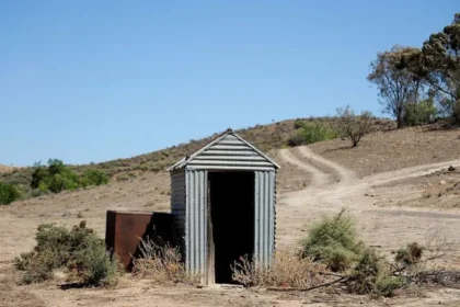 A woman was rescued after falling into a collapsed pit toilet in the Australian outback and being trapped for three hours before a passerby helped save her.