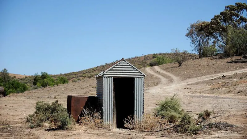 A woman was rescued after falling into a collapsed pit toilet in the Australian outback and being trapped for three hours before a passerby helped save her.