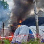 An outbreak of violence erupted at a hospital in eastern Democratic Republic of Congo after the death of a young man suspected of having Ebola. Family members and friends tried to take his body for burial but were stopped by health workers following strict safety rules to prevent infection. The situation quickly escalated. People in the crowd began throwing objects at the facility. Several tents used for isolation and treatment were set on fire. The incident took place at Rwampara General Hospital near Bunia in Ituri province, where most Ebola cases have been recorded. Police responded by firing warning shots to disperse the crowd and regain control of the area. Community reaction and confusion Witnesses said the deceased was a well known local football player. His mother believed he had died from typhoid rather than Ebola, which added to the tension. Local leaders reported that many people in the area do not trust official information about the virus. Some residents believe Ebola is not real or think it is linked to outside organizations and health programs for financial gain. Officials said this lack of trust and awareness is making the response more difficult, especially in remote communities. Medical response and security measures Health workers explained that Ebola burial protocols are essential because the virus remains highly contagious after death. Safe handling of bodies is necessary to prevent further spread. During the unrest, one healthcare worker was injured by stones thrown from the crowd. Medical staff were placed under military protection while security forces restored order at the hospital. Several treatment tents were destroyed in the fire, and at least one body prepared for burial was lost in the chaos. Government response Authorities described the situation as very serious and concerning for public safety. Officials stated that efforts are being increased to improve communication with local communities and to rebuild trust in health services. They emphasized the need for better public awareness so that families understand why strict medical procedures are required during outbreaks.